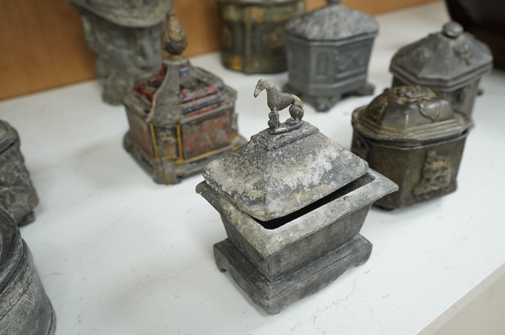 A collection of ten early 19th century lead tobacco boxes, one in the form of a goat’s head, tallest 20cm